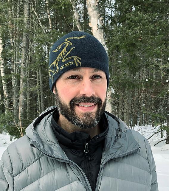 Man in an Arcteryx hat looking happy being outdoors