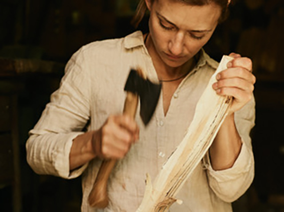 woman using axe to carve